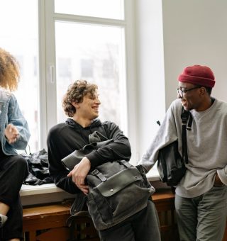 Um grupo de alunos conversando na sala de aula. Ao todo são quatro pessoas