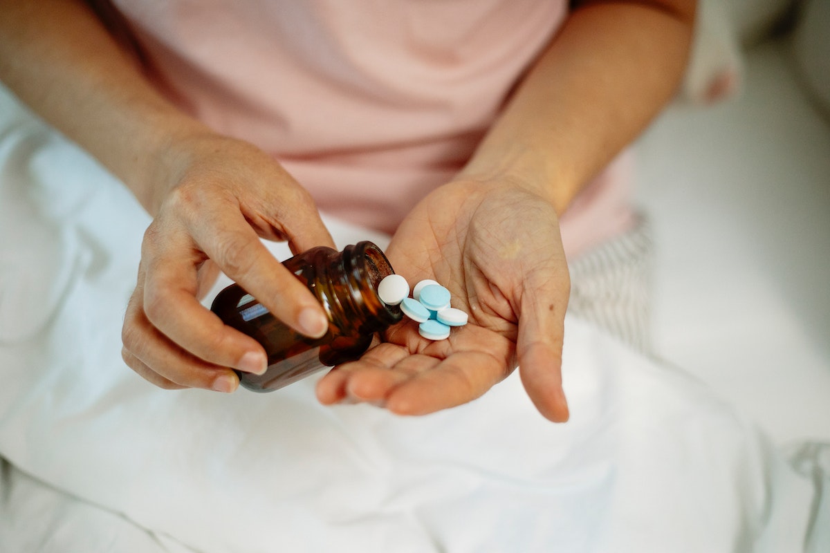 Uma pessoa está com pílulas de um remédio na palma da mão. Confira, os Direitos INSS para Pessoas com Síndrome do Pânico 2024
