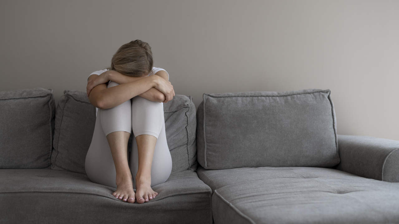 Mulher com depressão sentada no sofá